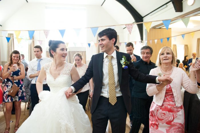 Bride and groom joining in the Greek dancing